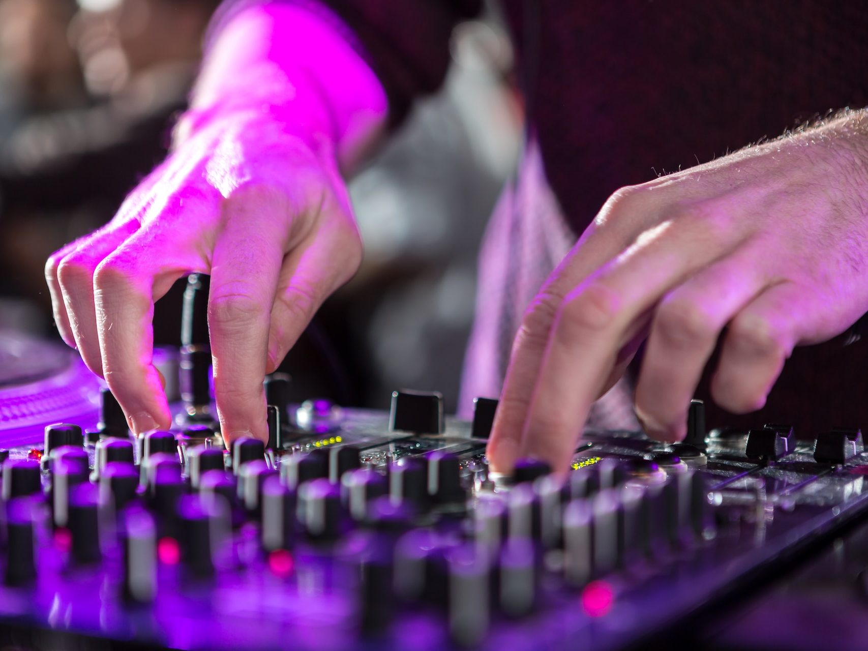 person in purple long sleeve shirt playing black audio mixer